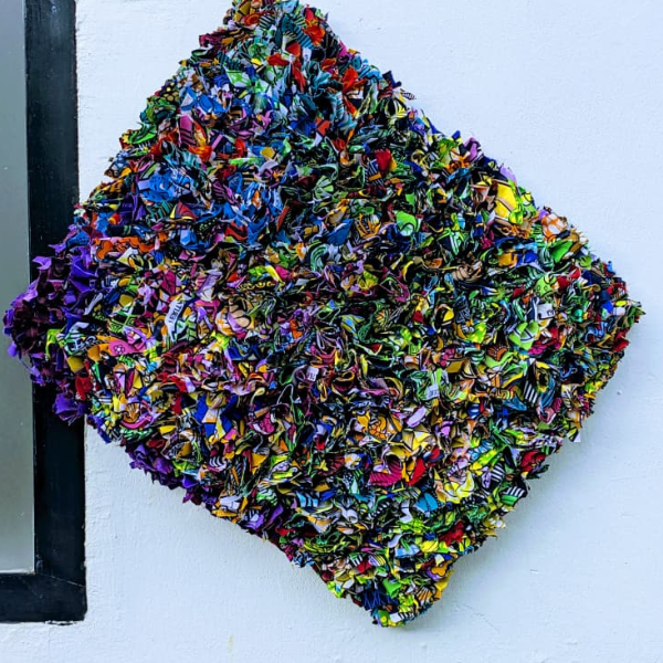 Artisanal Igitenge fabric mini carpet on a wooden floor.